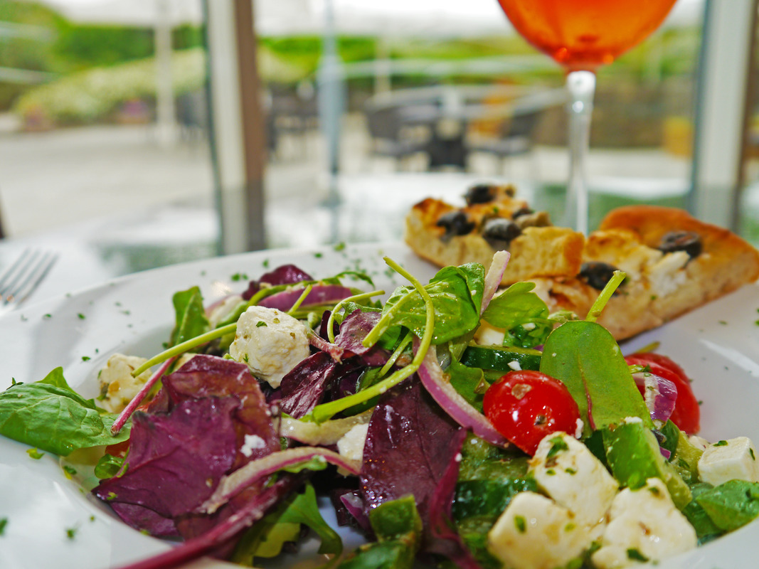 Greek Salad; feta cheese, vine cherry tomatoes, cucumber, red onion, black olives, green peppers, oregano, lemon and extra virgin olive oil dressing served with warm focaccia bread (v)